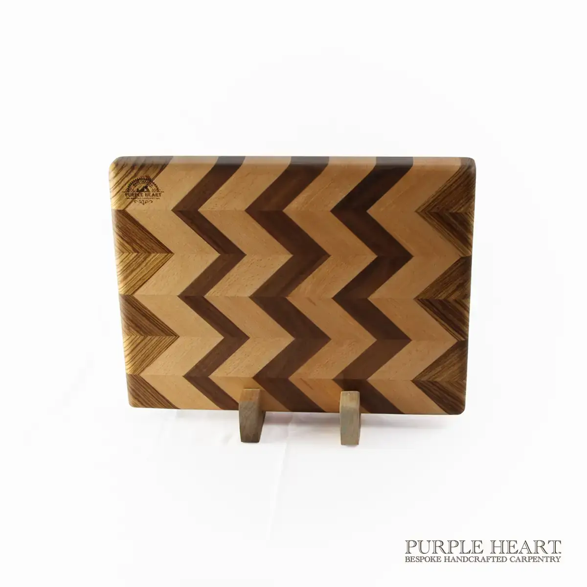 Handcrafted beech, walnut and zebrawood chevron wooden chopping board with geometric hardwood pattern
