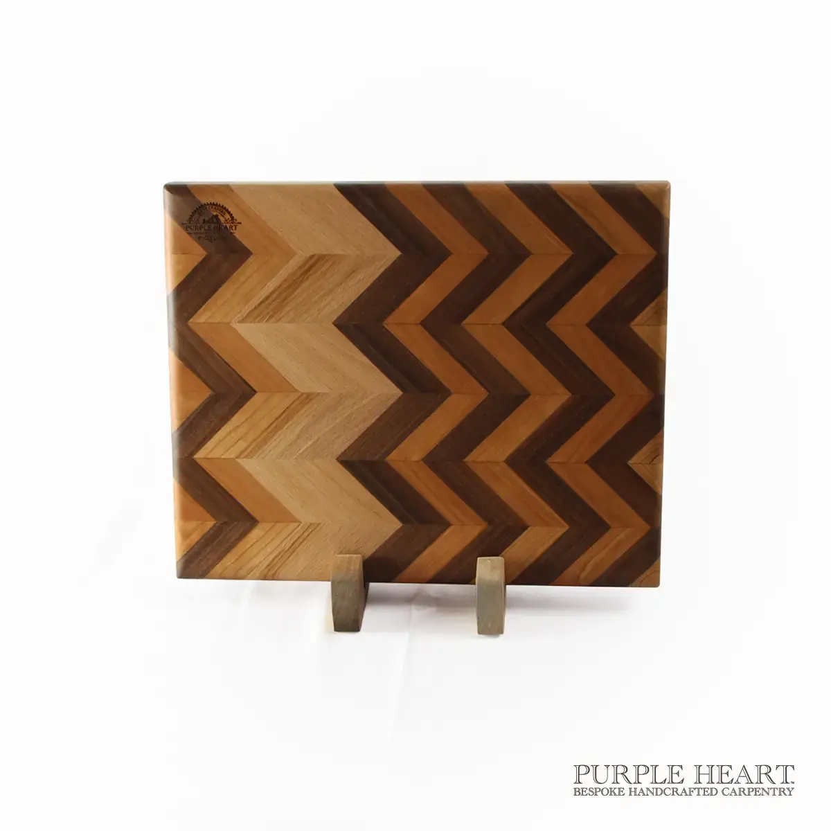 Handcrafted ash, beech and walnut chevron wooden chopping board with geometric hardwood pattern