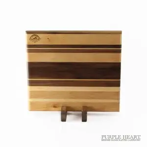 Handcrafted ash, cherry and walnut striped wooden chopping board with natural hardwood grain pattern