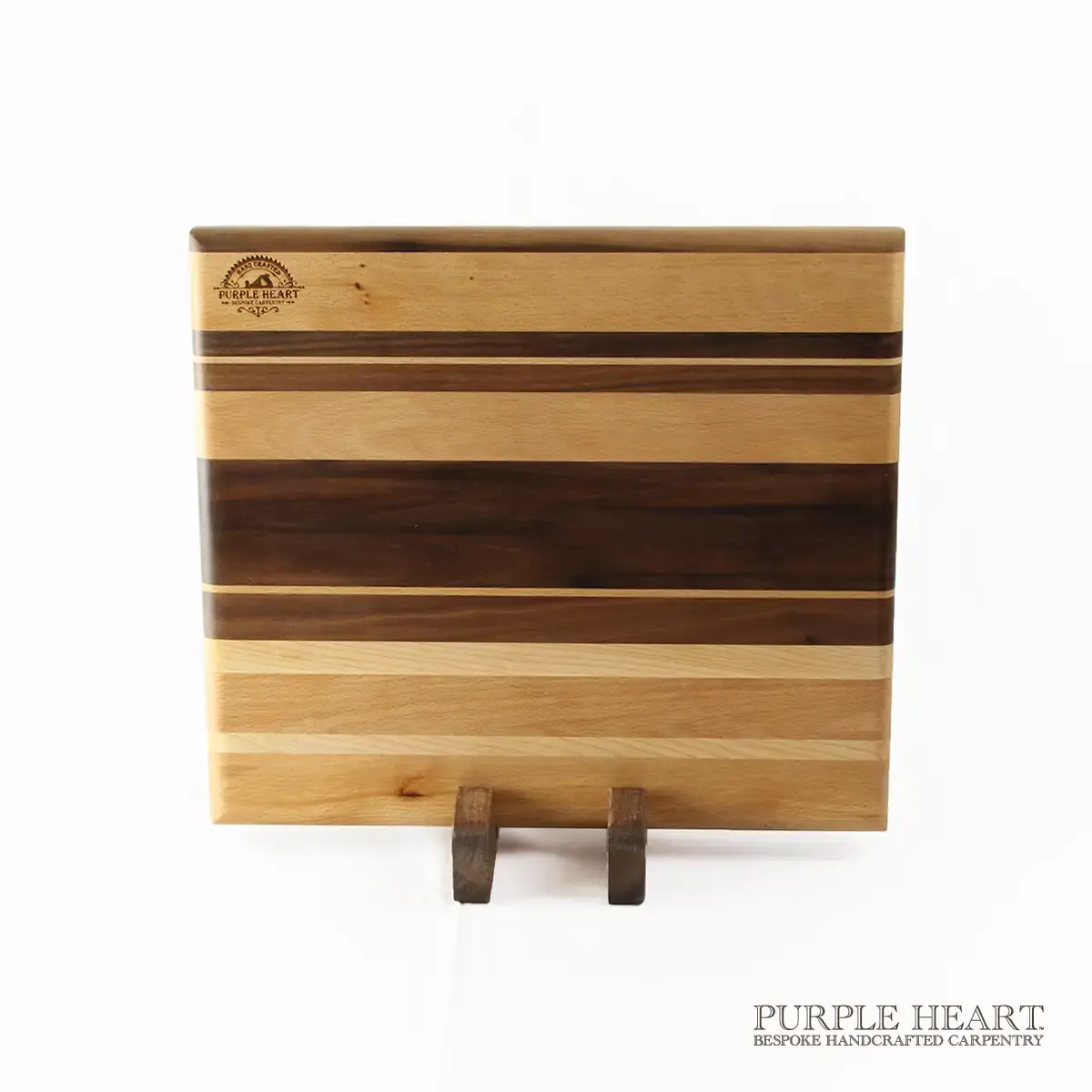 Handcrafted ash, cherry and walnut striped wooden chopping board with natural hardwood grain pattern