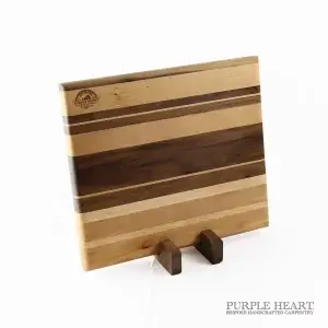 Handcrafted ash, cherry and walnut striped wooden chopping board with natural hardwood grain pattern