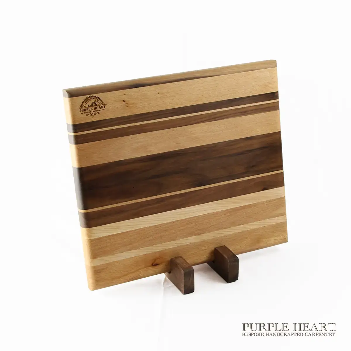 Handcrafted ash, cherry and walnut striped wooden chopping board with natural hardwood grain pattern